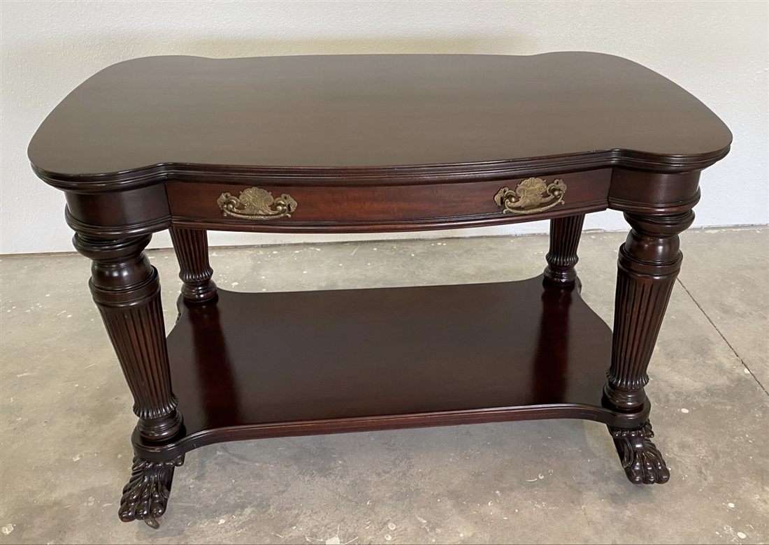 A restored mahogany library table with carved legs and brass hardware